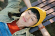 © Westend61 - Smiling woman in casual outfit relaxing on park bench outdoors