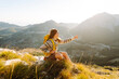 © maxbelchenko - A young woman with hiking backpack stands on mountain trail on sunny day. Female hiker with a yellow backpack enjoys mountain scenery at sunset. Concepts of adventure, freedom. Active lifestyle.