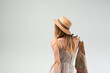 © Volodymyr_sh - Young woman seen from behind wearing summer dress and straw hat with reusable grocery bag, sustainable lifestyle concept