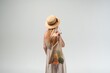 © Volodymyr_sh - Back view of young woman in summer dress and straw hat carrying reusable grocery bag with vegetables, sustainable living