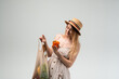 © Volodymyr_sh - Young woman choosing fresh vegetables from reusable mesh bag, healthy eating and sustainable shopping concept