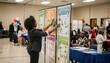 © Justlight - Community center indoor health fair with a volunteer placing educational posters on display boards capturing numerous blurred attendees engaging in other areas behind.