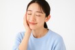 © AnilaStudio - 目を閉じて頬に手を当てる若い日本人女性のポートレート