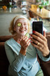 © Geber86 - Senior woman taking selfie with cucumber face mask at home
