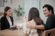 © surachetkhamsuk - Asian financial consultant explaining new project investment to young couple in office. Real estate agent discussing mortgage options with family. Mortgage loan consultation.