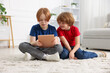 © New Africa - Cute brothers with tablet on floor at home