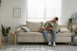 © New Africa - Young man with his cute dog relaxing on sofa at home