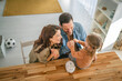 © Miljan Živković - Family teaching daughter about saving money with piggy bank