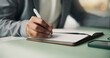 © WesJVR/peopleimages.com - Creative, writing and hands with notebook, office and planning for ad campaign, project and schedule. Business, copywriter and person with journal for research, ideas and notes for article on desk