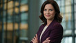 © Yka - Female executive in purple suit standing against modern building background