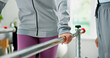 © MagicDavid25/peopleimages.com - Physiotherapy, walking and hands with person and rail for support, rehabilitation or recovery. Physical therapy, medical check up or consulting with patient and physiotherapist in clinic for mobility