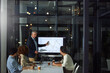 © peopleimages.com - Speaker, presentation and people in office at night with finance report, data analysis and profit. Mature man, team and screen with sales growth, financial graphs and overtime for performance metrics