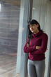 © wavebreak3 - Female crossing arms inside building gazing through wet glass to deck, copy space