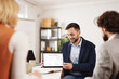 © Stockphotodirectors - A man shows a tablet to his colleagues during a meeting in an office. They collaborate on plans and share ideas to achieve success.