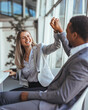 © Dragana Gordic - Business Professionals Celebrate a High Five in a Modern Office, Demonstrating Teamwork and Positive Energy