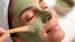 © Anastasiia - A spa treatment where a green clay facial mask is being applied to a person’s face with a brush. Concept Spa Treatment, Green Clay Mask, Facial Mask Application with Brush, Relaxing Spa Scene