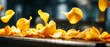 © Anoo - Potato chips are flying in the air as they are processed on a conveyor belt in a dark setting, highlighting the production process and movement
