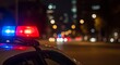 © Olga - Police car with red and blue emergency lights parked at night, blurred background