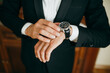 © Iryna - Man in classic tuxedo checking time on elegant watch
