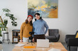 © Studio Marmellata - Two young women with headphones are setting up a camera and laptop for a video recording session in a bright, modern room.