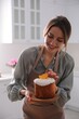© New Africa - Young woman with traditional decorated Easter cake in kitchen