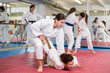 © JackF - Group of women in kimonos training judo techniques in pairs in studio