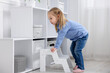 © New Africa - Child safety at home. Little girl climbing in step ladder indoors