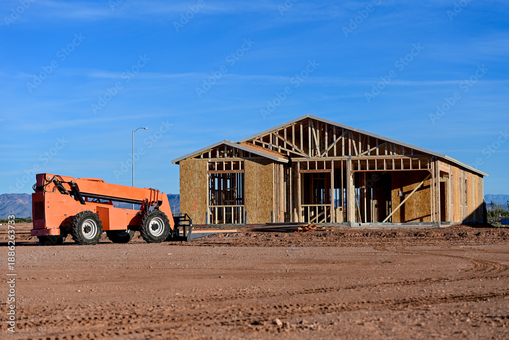 Top Loader Building Telehandler lifting materials at a wood framed residential building ...
