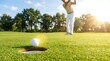 © Khela - Golfer hitting ball near hole on lush green course at sunset