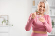 © Pixel-Shot - Sporty mature woman taking collagen powder at home
