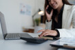 © crizzystudio - Professional woman calculating budget during business call
