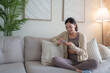 © crizzystudio - Young asian woman using smartphone relaxing on sofa at home