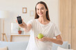 © Pixel-Shot - Young pregnant woman with gestational diabetes holding glucometer and apple at home