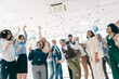 © deagreez - Diverse Group of Professionals Celebrating in a Modern Office Environment with Joy and Collaboration