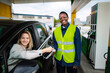 © Jelena - Gas station worker helping customer with contactless payment