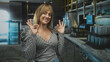 © Krakenimages.com - Woman pointing and giving thumbs up in a stainless commercial kitchen building, hand on hip and smiling into camera; approval.