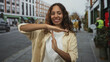 © Krakenimages.com - Woman making a time out gesture with hands on a busy city street lined with shops and pedestrians; confidence.