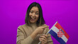 © Krakenimages.com - Smiling woman pointing at croatian flag with vibrant pink background highlighting national pride and joyful expression.