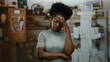 © Krakenimages.com - Woman looking worried in quiet room with shelves hinting at thoughtful ambiance, showcasing emotion and introspection in a casual indoor setting