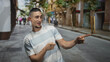 © Krakenimages.com - Man hands gesturing and pointing on a busy street, smiling and talking while wearing a striped tshirt; playful conversation.