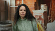 © Krakenimages.com - Young hispanic woman wearing sweater standing indoors at construction site with a serious expression amidst unfinished house