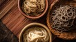 © mila103 - Three bowls of noodles are displayed on a wooden table. The bowls are filled with different types of noodles, including white, brown, and gray. Concept of variety and abundance
