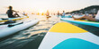 © Bonsales - Group of people paddle boarding at sunset, reflecting a peaceful summer vacation and water sport leisure activity
