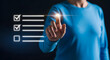 © MistoGraphy - Man in blue shirt interacting with virtual checklist futuristic technology concept glowing checkmarks and empty box on dark background