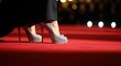 © Herlita - Person wearing sparkling high heeled footwear walks upon a vibrant red carpet event