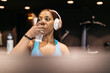 © ADDICTIVE STOCK - Woman relaxing after workout with headphones in hotel gym