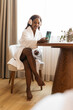 © ADDICTIVE STOCK - Woman relaxing in hotel room with headphones and smartphone