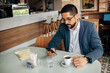 © kleberpicui - Business man using smartphone in cafe. Concepts of remote work, freelance lifestyle, business routine, technology, urban life and modern professional