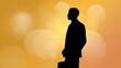 © buraratn - Silhouette of Businessman Standing Against a Yellow Background with Soft Focus Bokeh Lights, Symbolizing Professionalism and Success in Corporate World