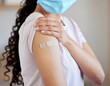 © Iwan - Woman showing vaccination band-aid on arm after receiving vaccine